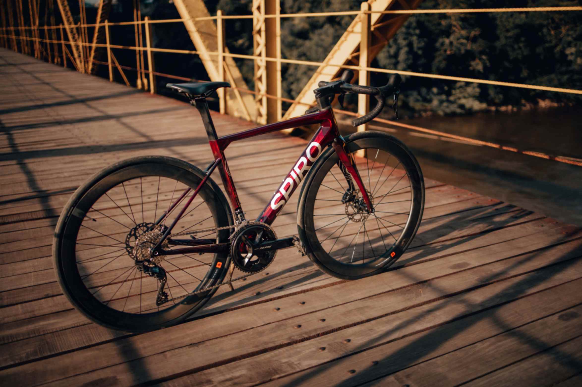 Spiro Legend, bicicleta de ruta de carbono con frenos hidráulicos y grupo Shimano 105, posicionada contra la Trek Émonda y Scott Addict.